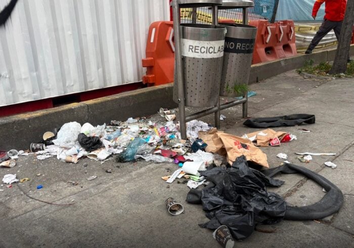 El fracasada estrategia de Galán para limpiar la ciudad de basuras que ha costado .000 millones y no ha servido Trash and litter spilled onto a city sidewalk near recycling bins and construction barriers. - El fracasada estrategia de Galán para limpiar la ciudad de basuras que ha costado .000 millones y no ha servido