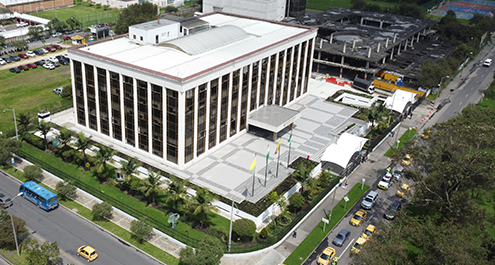 Los Char van por el millonario contrato de medicamentos para la Policía Aerial view of a large white multi-story building with tall columned facade, surrounded by a plaza and green lawns. - Los Char van por el millonario contrato de medicamentos para la Policía