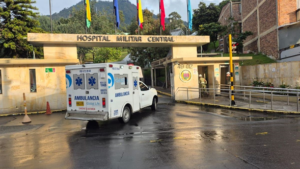 La coronel médica que se estrena como directora del Hospital Militar hereda una dura multa por un contrato que no firmó Ambulance van parked at the entrance of Hospital Militar Central under a row of colorful flags fly above the gate. - La coronel médica que se estrena como directora del Hospital Militar hereda una dura multa por un contrato que no firmó