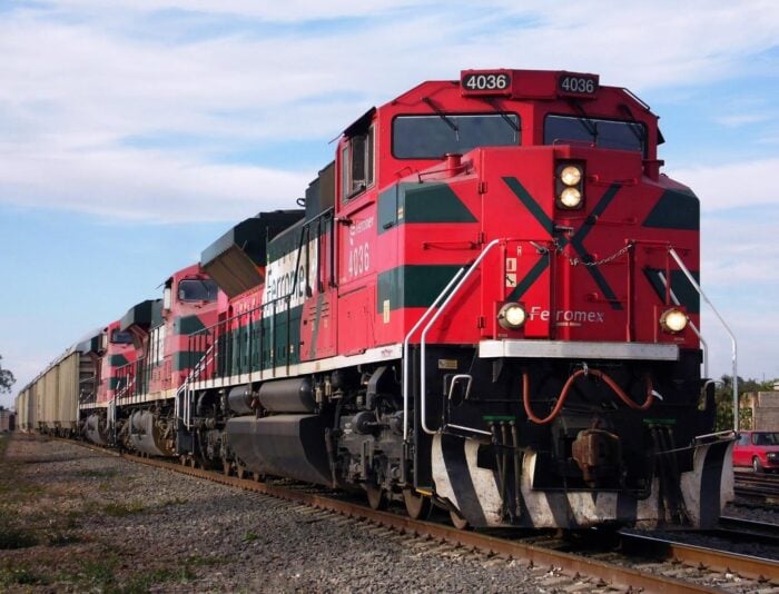 Los negocios que llevaron a la cima a los cinco más ricos de América Latina entre los que hay un colombiano Red Ferromex freight locomotive #4036 leads a long line of cargo cars on a sunny day. - Los negocios que llevaron a la cima a los cinco más ricos de América Latina entre los que hay un colombiano