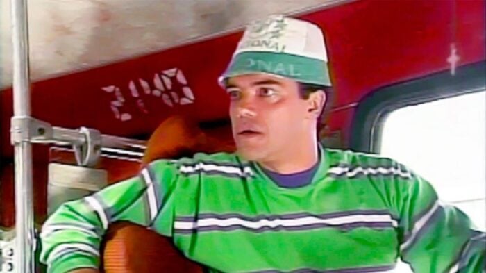 Luis Eduardo Arango, el actor paisa que se resiste a dejar la actuación en la que lleva más de medio siglo Man in a green striped shirt and cap sits on a red bus, looking surprised/ startled. - Luis Eduardo Arango, el actor paisa que se resiste a dejar la actuación en la que lleva más de medio siglo