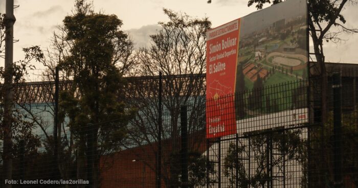 Después de diecisiete años y nueve contratos por más de .000 millones la Unidad Deportiva Salitre sigue igual Large construction sign for Parque Estructurante Simón Bolivar at El Salitre, seen behind a chain-link fence with bare trees. - Después de diecisiete años y nueve contratos por más de .000 millones la Unidad Deportiva Salitre sigue igual