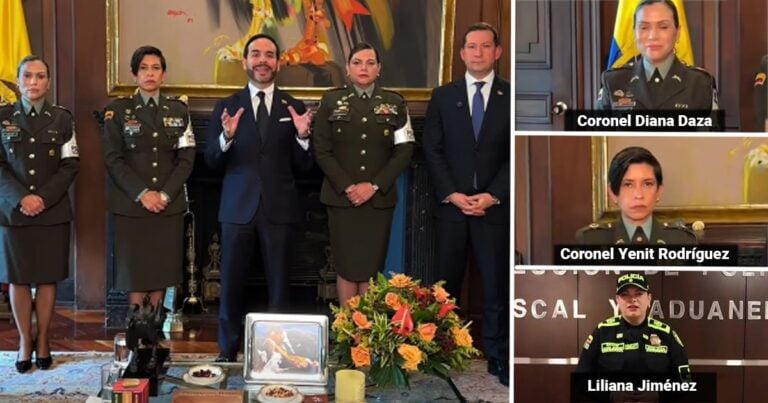 Five people in a ceremonial room: four uniformed officers and a man in a suit speak beside a small memorial with a framed photo and flowers. - Las2orillas.co: Historias, voces y noticias de Colombia