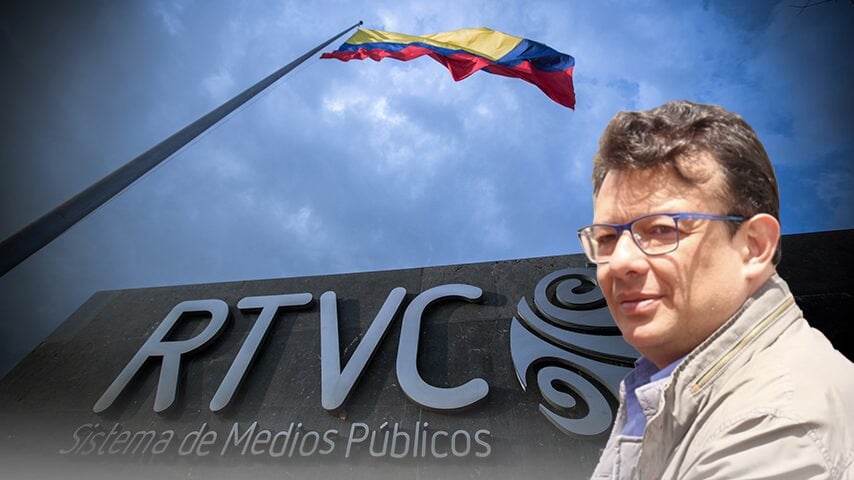 Selfie of a man with glasses standing in front of a public media building sign RTVC with a Colombian flag overhead - Hollman Morris dejó la olla raspada y la nueva gerente no encontró plata ni para pagar la luz y los sueldos