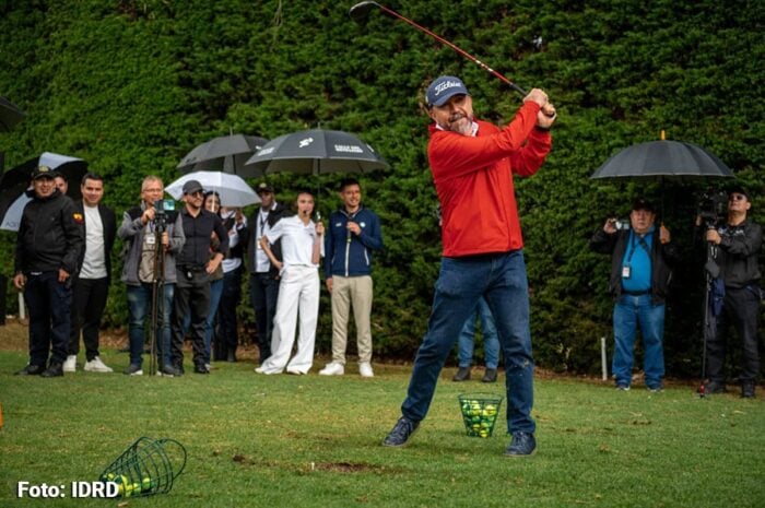 Cómo logró Galán recuperar el campo de golf del Parque La Florida para que se pueda jugar sin gastar mucha plata Golfer in a red jacket mid-swing on a grassy course with spectators and photographers under umbrellas.", - Cómo logró Galán recuperar el campo de golf del Parque La Florida para que se pueda jugar sin gastar mucha plata