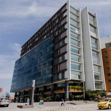 Modern glass-and-concrete office building along a street, with cars in the foreground. - El exsenador que lideró la campaña del No contra el acuerdo de Santos y las Farc que De la Espriella envía a Ecuador