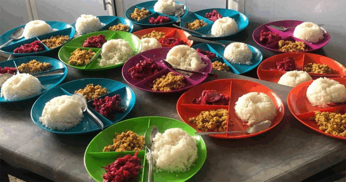 El fantasma del zar del PAE sigue rondando y hoy la Contraloría tiene mil millones bajo la lupa Colorful plates on a table, each with a mound of white rice and two portions of side dishes. - El fantasma del zar del PAE sigue rondando y hoy la Contraloría tiene mil millones bajo la lupa