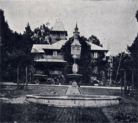 La historia de imponente hacienda sobre la que se levantó Corferias y su barrio vecino Quinta Paredes Old-fashioned fountain in a circular basin with a statue, set in front of an ivy-covered house and vintage car in a park-like setting. - La historia de imponente hacienda sobre la que se levantó Corferias y su barrio vecino Quinta Paredes